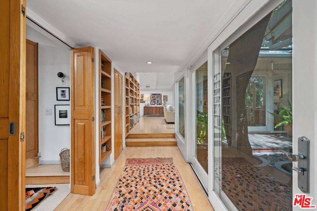 1827 Old Ranch Road Los Angeles, CA 90049 - Photo 4 of 39 a view of a hallway with wooden floor and living room