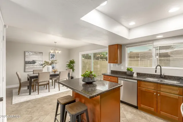 a kitchen with granite countertop sink stove and dining table