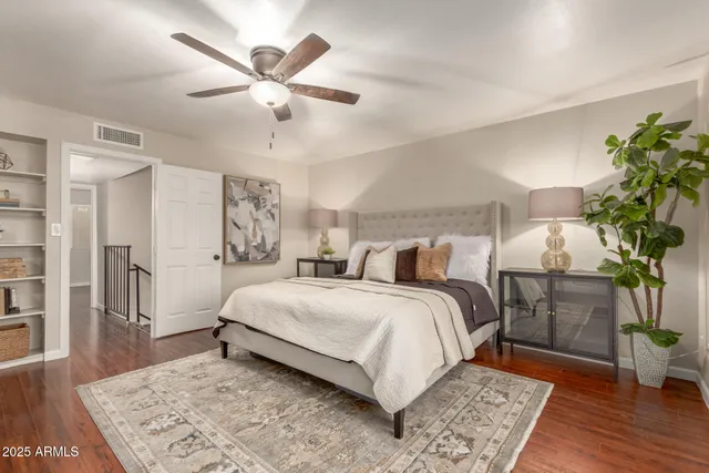 a bedroom with a large bed and a wooden floor