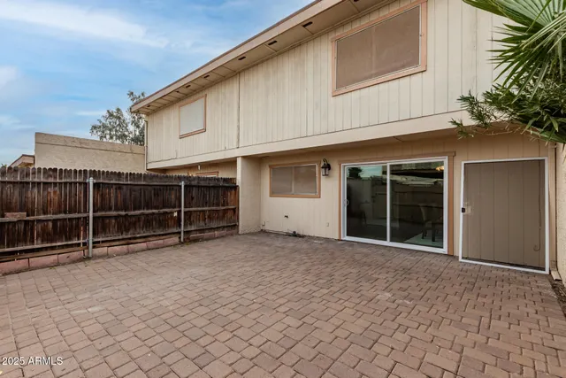 a view of a house with a large window and wooden fence