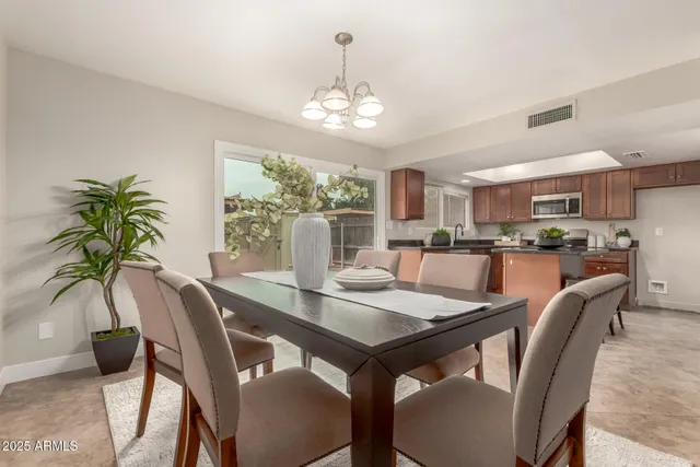 a dining room with furniture a chandelier and window
