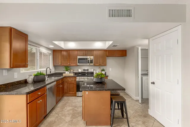 a kitchen with stainless steel appliances a sink a stove top oven a counter space and cabinets