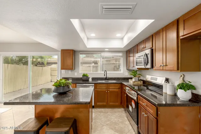 a kitchen with stainless steel appliances granite countertop sink stove and cabinets