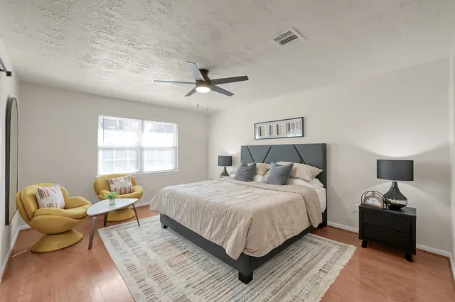 a bedroom with a bed and wooden floor