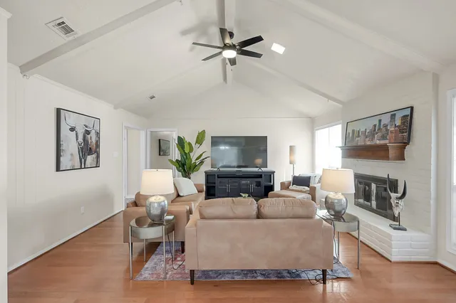 a living room with furniture a fireplace and a flat screen tv