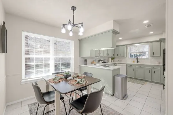 a kitchen with a stove a sink a dining table and chairs