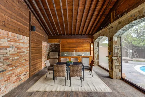 a view of a patio with table and chairs and wooden floor