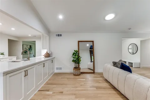 a living room with furniture mirror and wooden floor