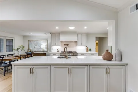 a kitchen with sink stove and cabinets
