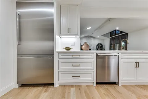 a kitchen with white cabinets and refrigerator
