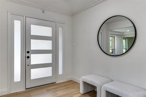 a view of a livingroom with wooden floor and a mirror
