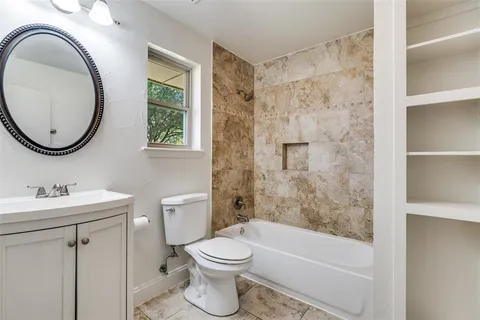 a bathroom with a toilet a sink a bath tub and a mirror