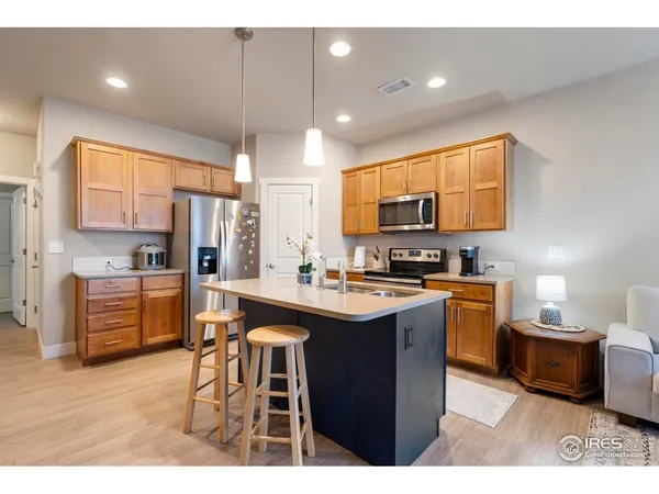 a kitchen with stainless steel appliances kitchen island granite countertop a sink and cabinets