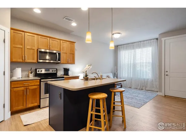 a kitchen with stainless steel appliances granite countertop a sink a stove a microwave and wooden cabinets