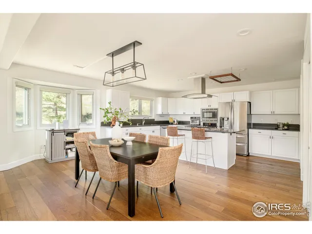 a dining hall with stainless steel appliances kitchen island granite countertop a dining table and chairs