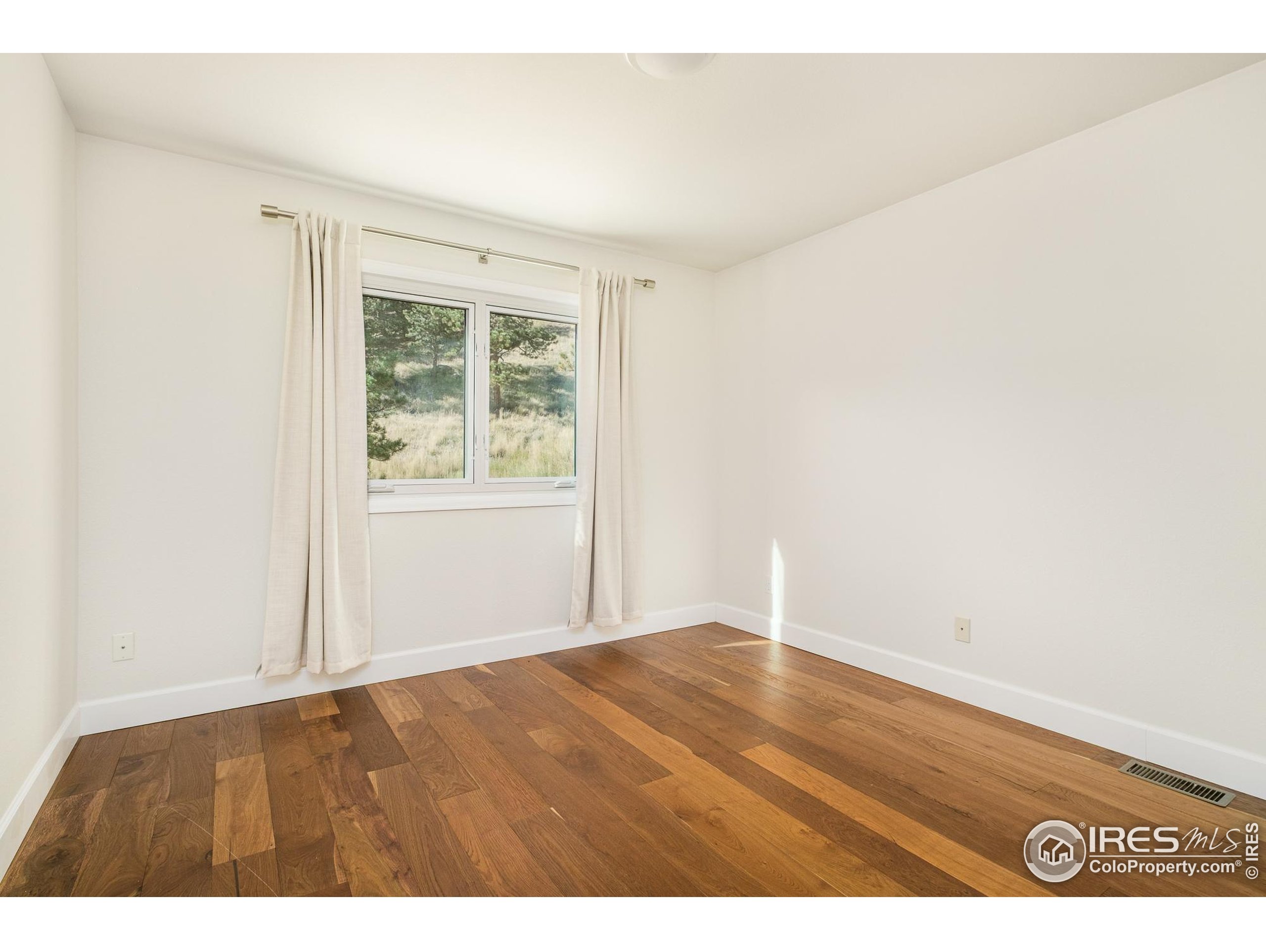 270 Canon View Road Boulder, CO 80302 - Photo 34 of 48 an empty room with wooden floor and windows