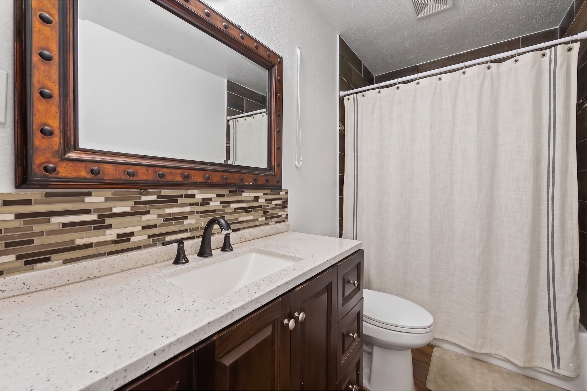 6014 Linda Drive Rosharon, TX 77583 - Photo 14 of 22 The bathroom features a full bathtub and shower combination showcased by elegant, floor-to-ceiling wood-look wall tiling.
