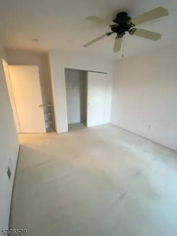 en empty room with windows and a ceiling fan