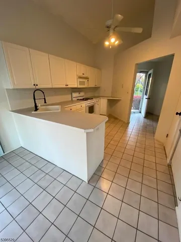 a large white kitchen with a sink and washing machine