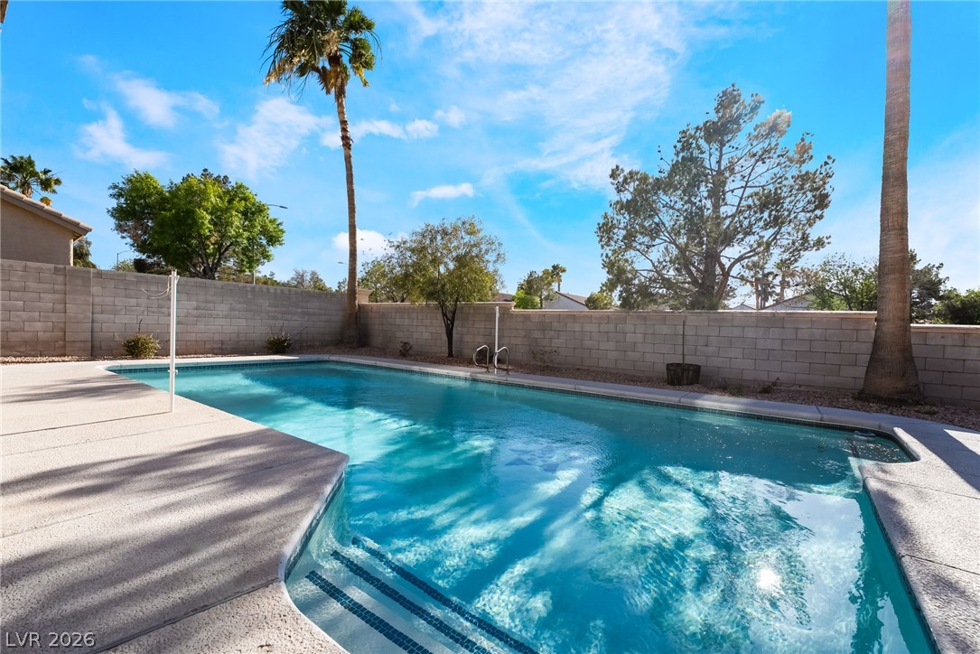 261 Timber Hollow Street Henderson, NV 89012 - Photo 48 of 51 An inviting backyard oasis offers a crystal-clear pool, perfect for leisure under the open sky.