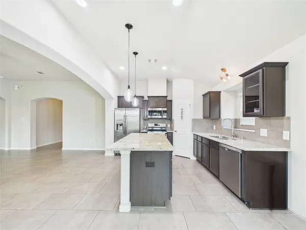 a large kitchen with kitchen island a sink stainless steel appliances and cabinets