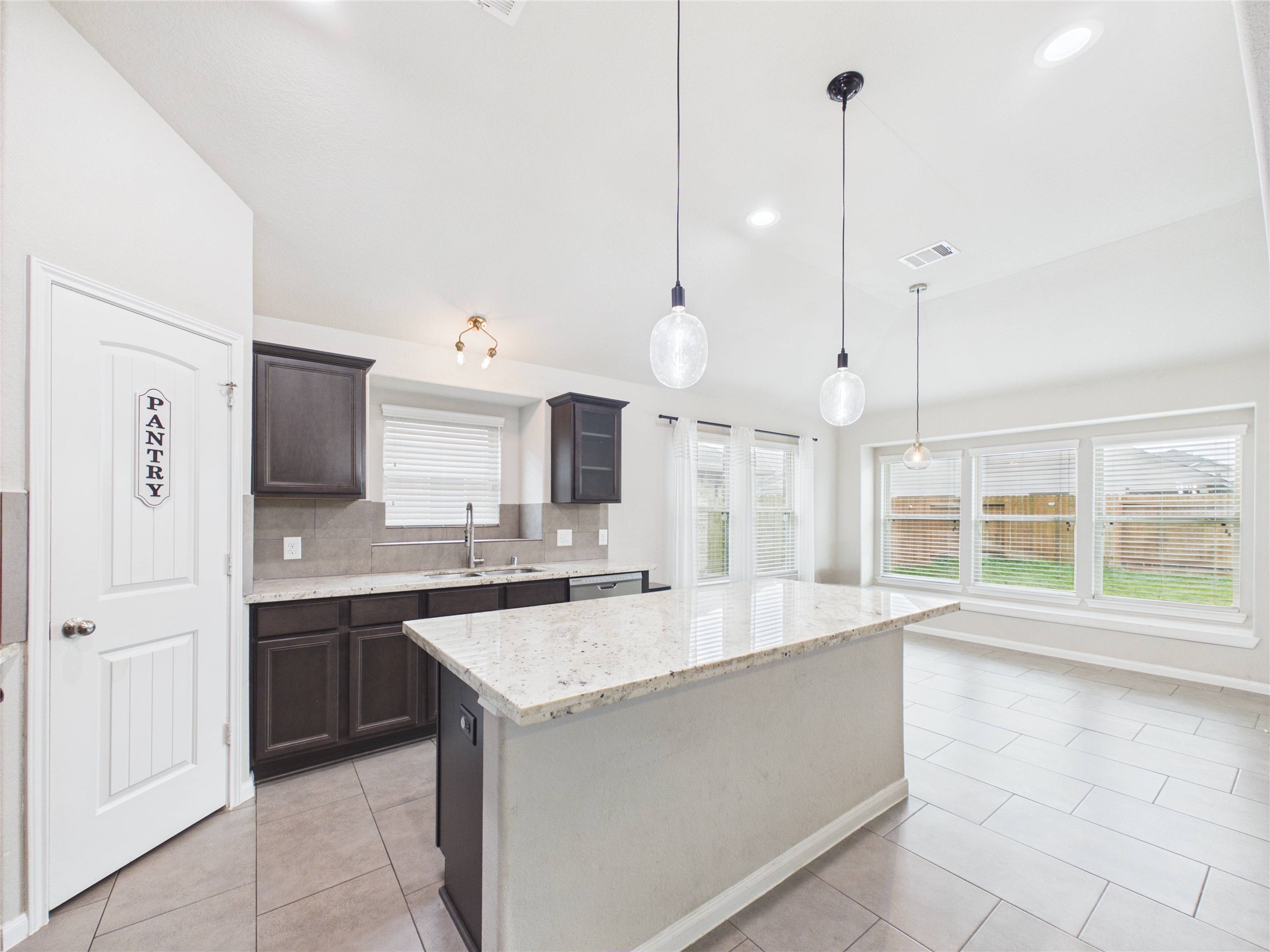 721 Rim Water Drive Alvin, TX 77511 - Photo 14 of 40 a large kitchen with kitchen island a large counter top a sink stainless steel appliances and cabinets