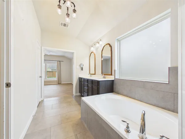 a bathroom with a tub shower and sink