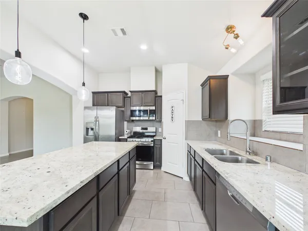 a open kitchen with stainless steel appliances granite countertop a sink stove and refrigerator