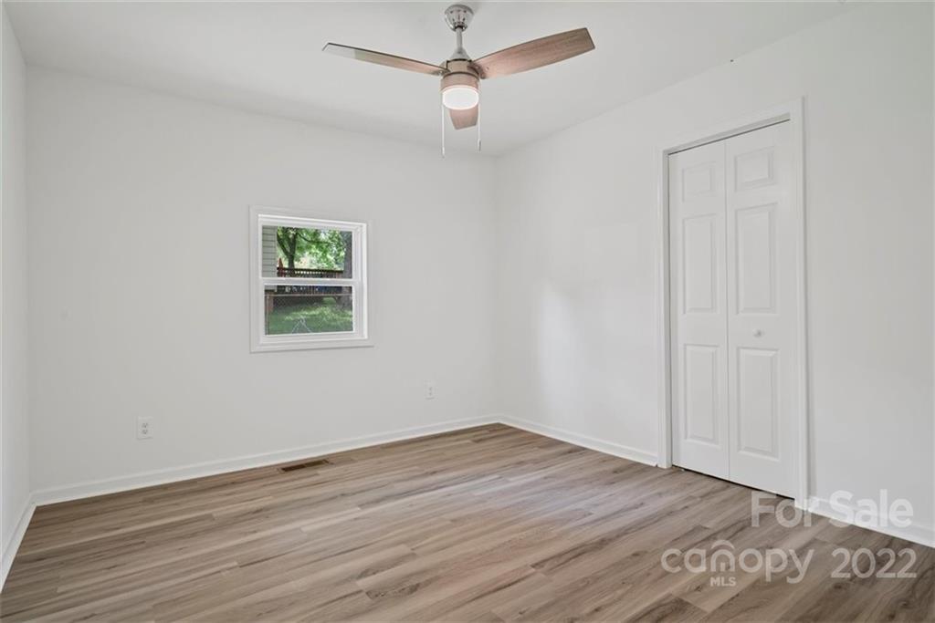 500 3rd Street Stanley, NC 28164 - Photo 15 of 19 an empty room with wooden floor ceiling fan and windows