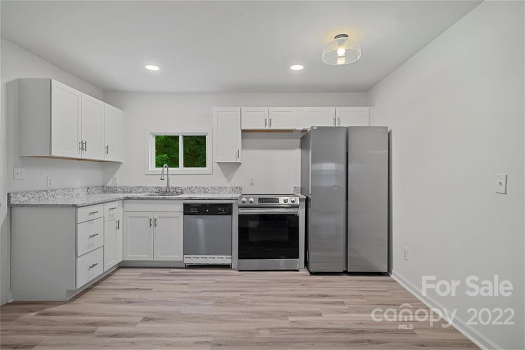 500 3rd Street Stanley, NC 28164 - Photo 10 of 19 a kitchen with stainless steel appliances granite countertop a stove a sink and a refrigerator