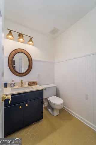 a bathroom with a toilet a sink and a mirror