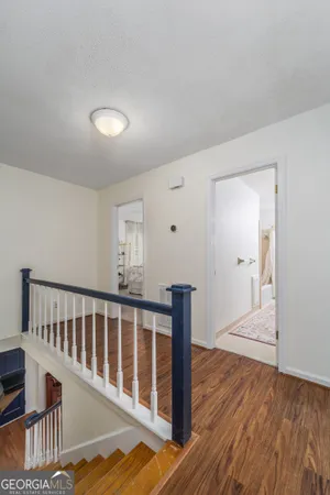 a view of a hallway with wooden floor and cabinet