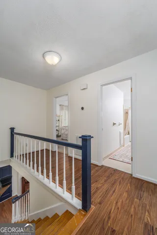 a view of a hallway with wooden floor and cabinet