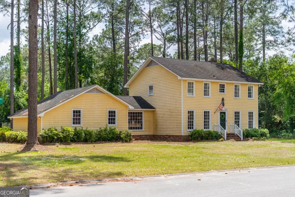 a front view of a house with a garden and yard