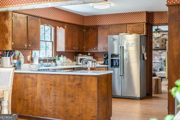 a kitchen with stainless steel appliances granite countertop a refrigerator a sink and a cabinets