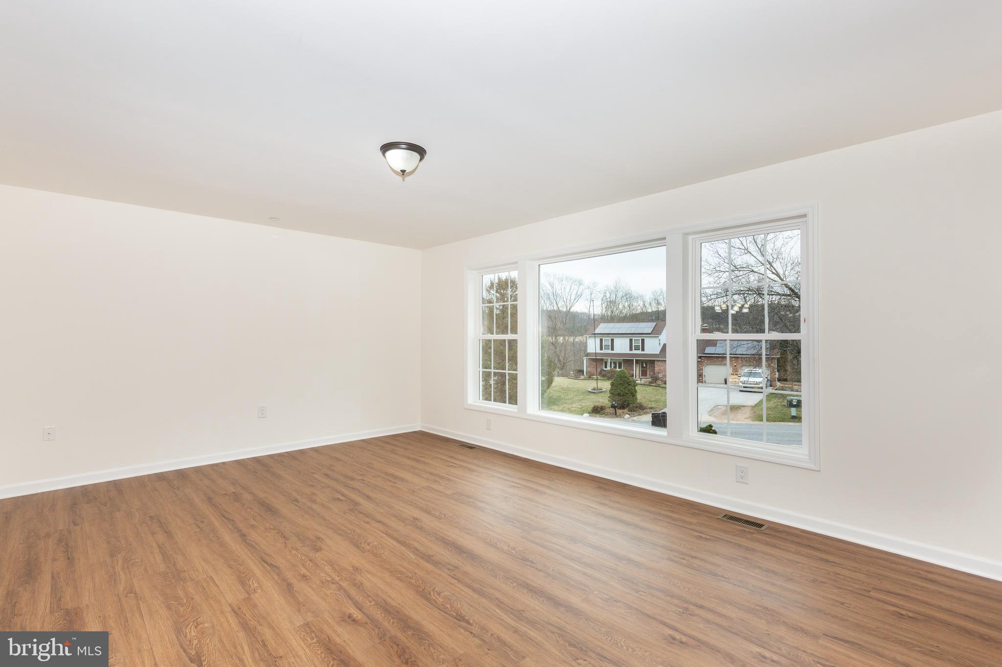 3406 Viewridge Circle Manchester, MD 21102 - Photo 20 of 57 a view of an empty room with wooden floor and a window