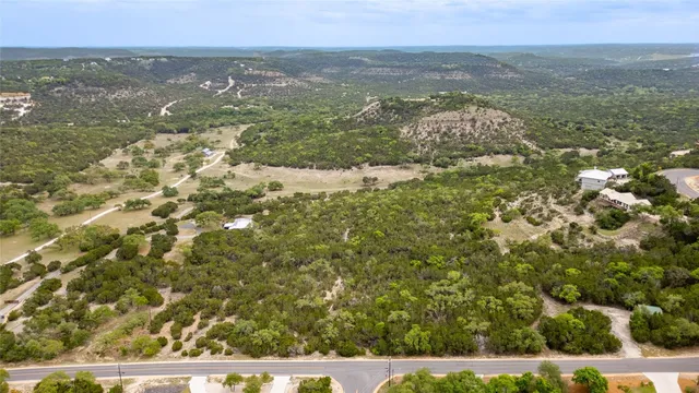 an aerial view of residential houses with outdoor space and trees