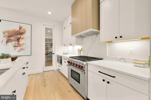 a kitchen with a stove and a wooden floor