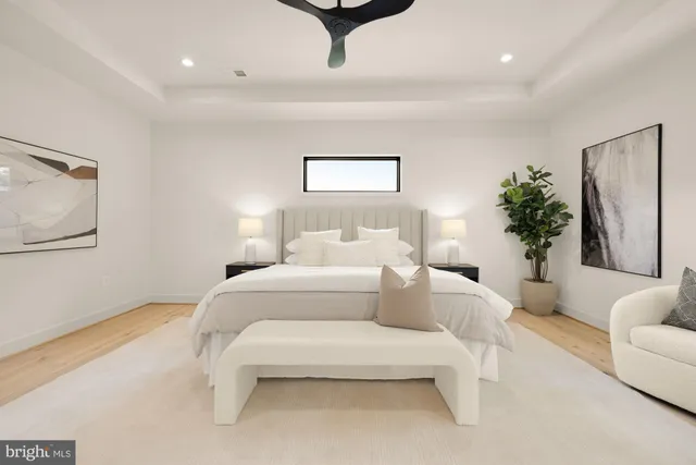 a spacious bedroom with a large bed a chandelier and a window
