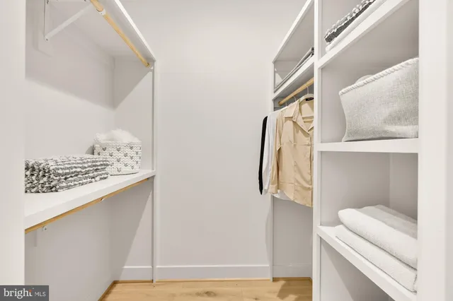 a view of walk in closet with clothes and shoes