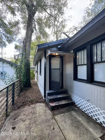 a view of house with a small yard and wooden fence
