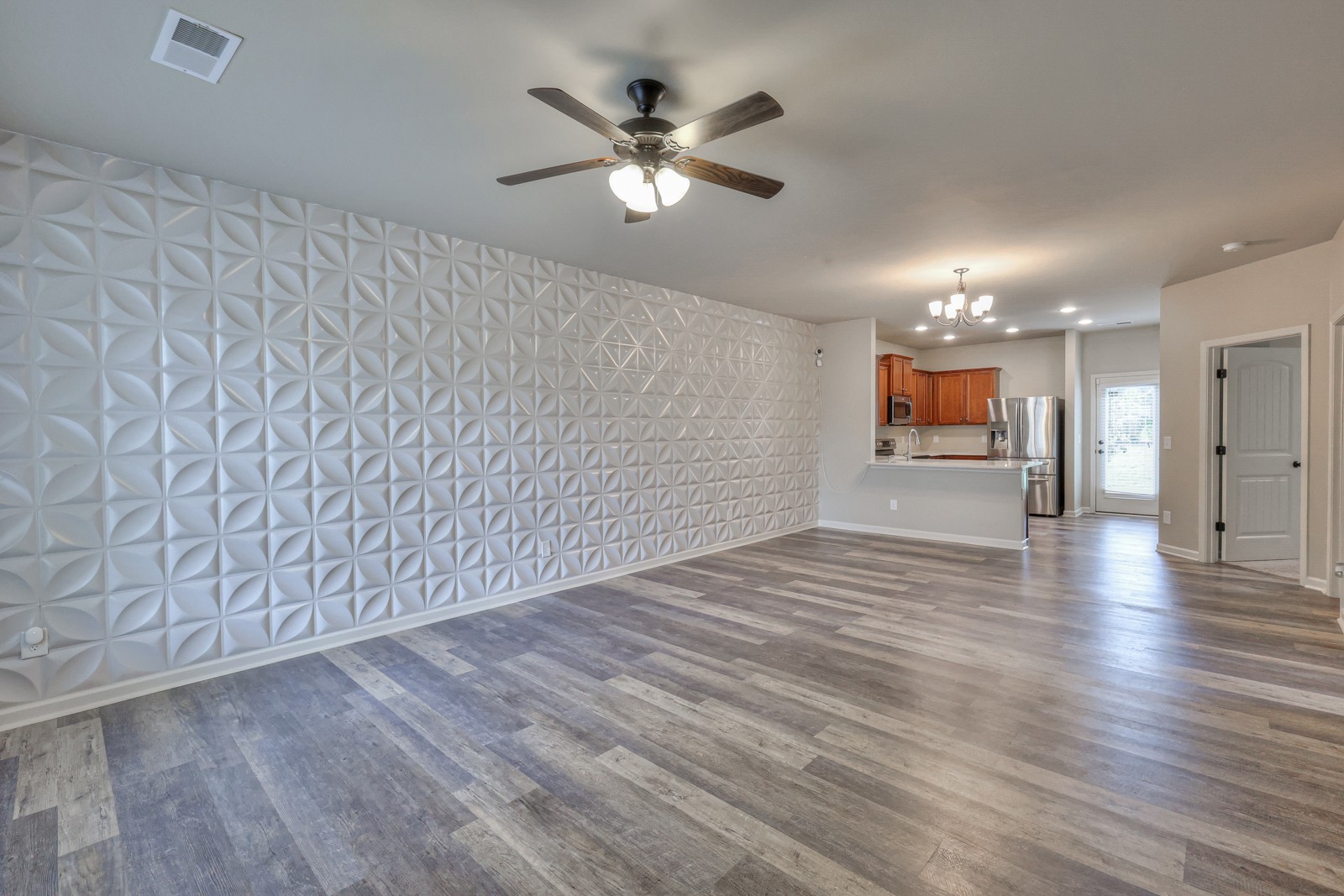 911 Brigade Loop Murfreesboro, TN 37128 - Photo 3 of 29 wooden floor in an empty room with a ceiling fan and window