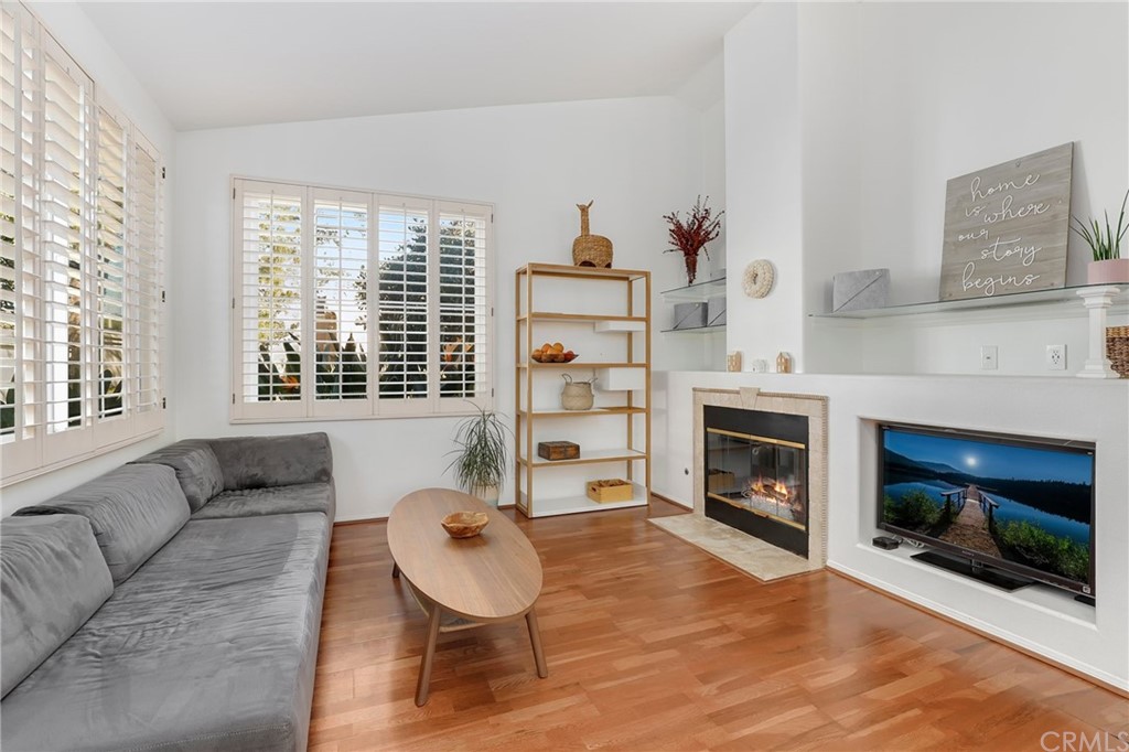a living room with furniture a fireplace and a large window