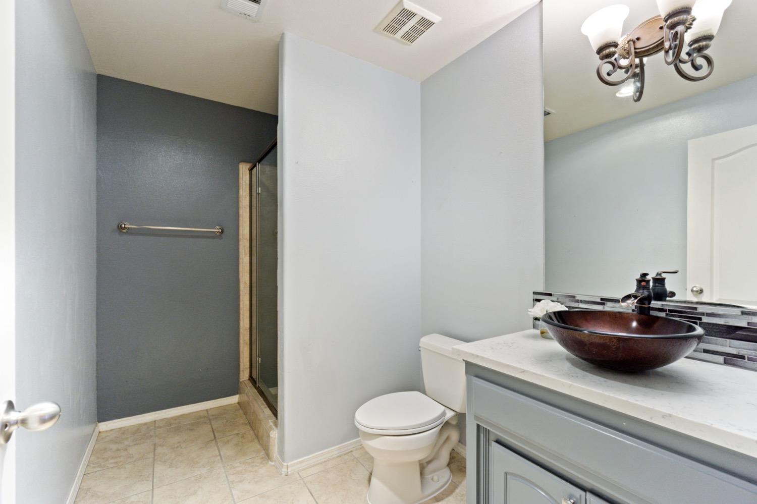 3089 Express Court Madera, CA 93637 - Photo 15 of 39 a bathroom with a toilet a sink and a mirror
