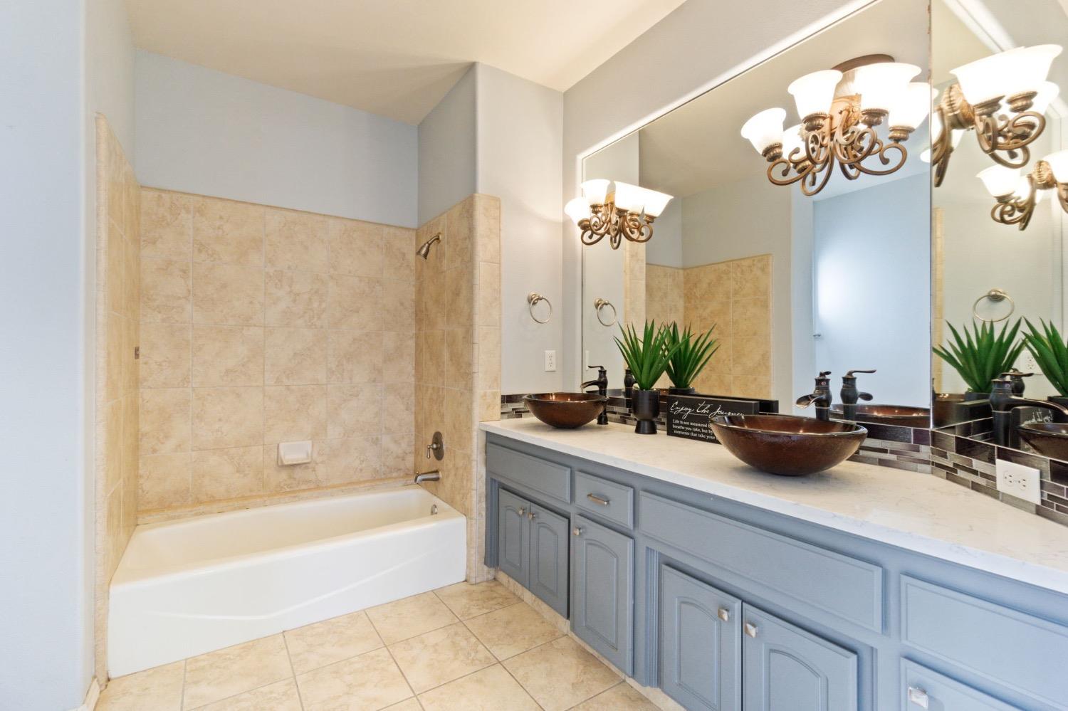 3089 Express Court Madera, CA 93637 - Photo 16 of 39 a bath room with a mirror and a bath tub