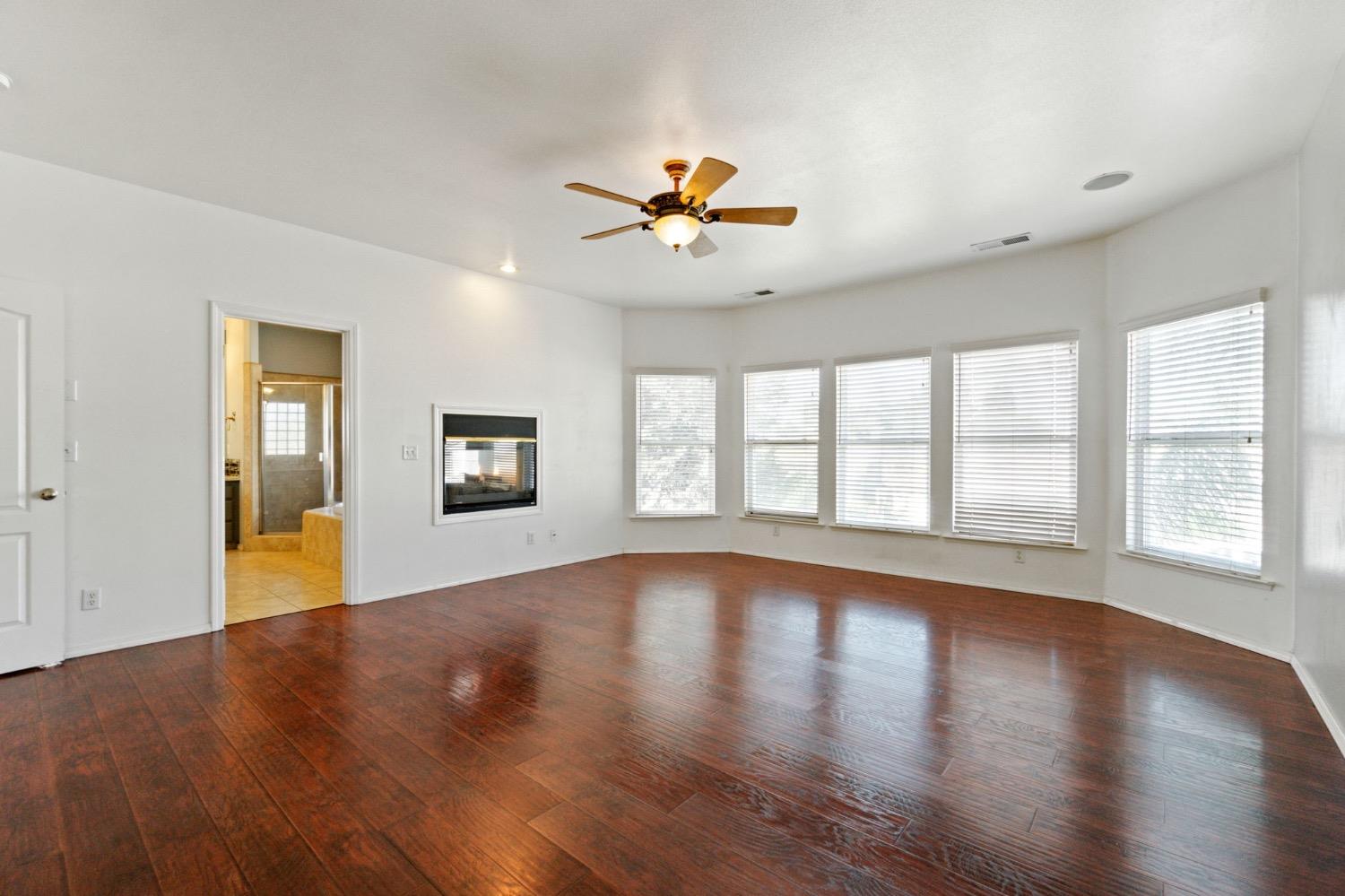 3089 Express Court Madera, CA 93637 - Photo 17 of 39 a view of an empty room with a window and wooden floor