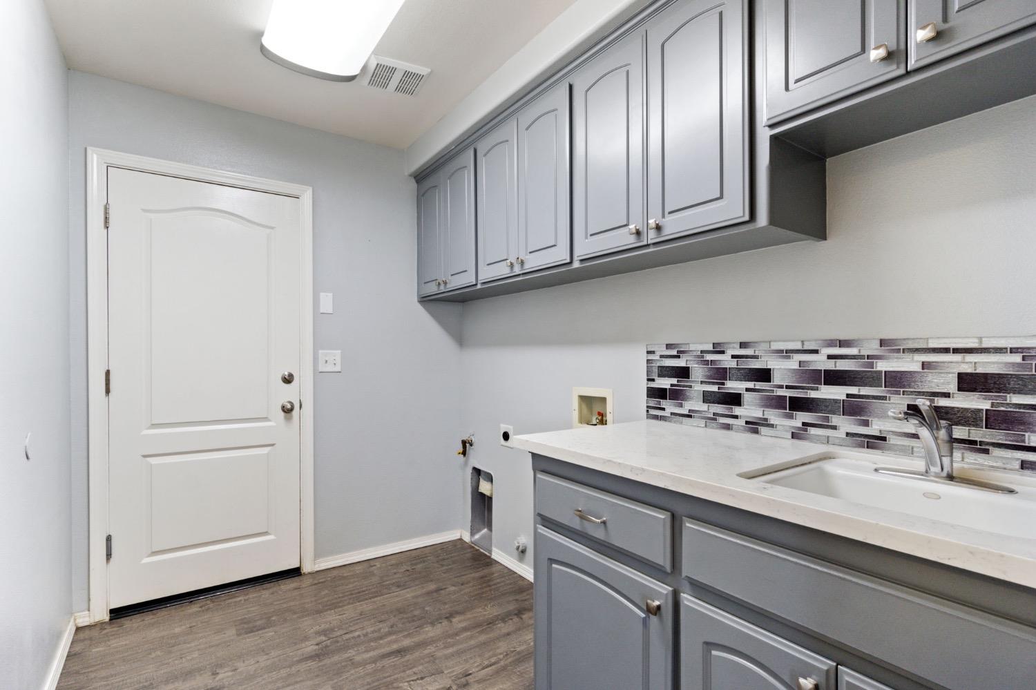 3089 Express Court Madera, CA 93637 - Photo 23 of 39 a kitchen with a sink cabinets and wooden floor