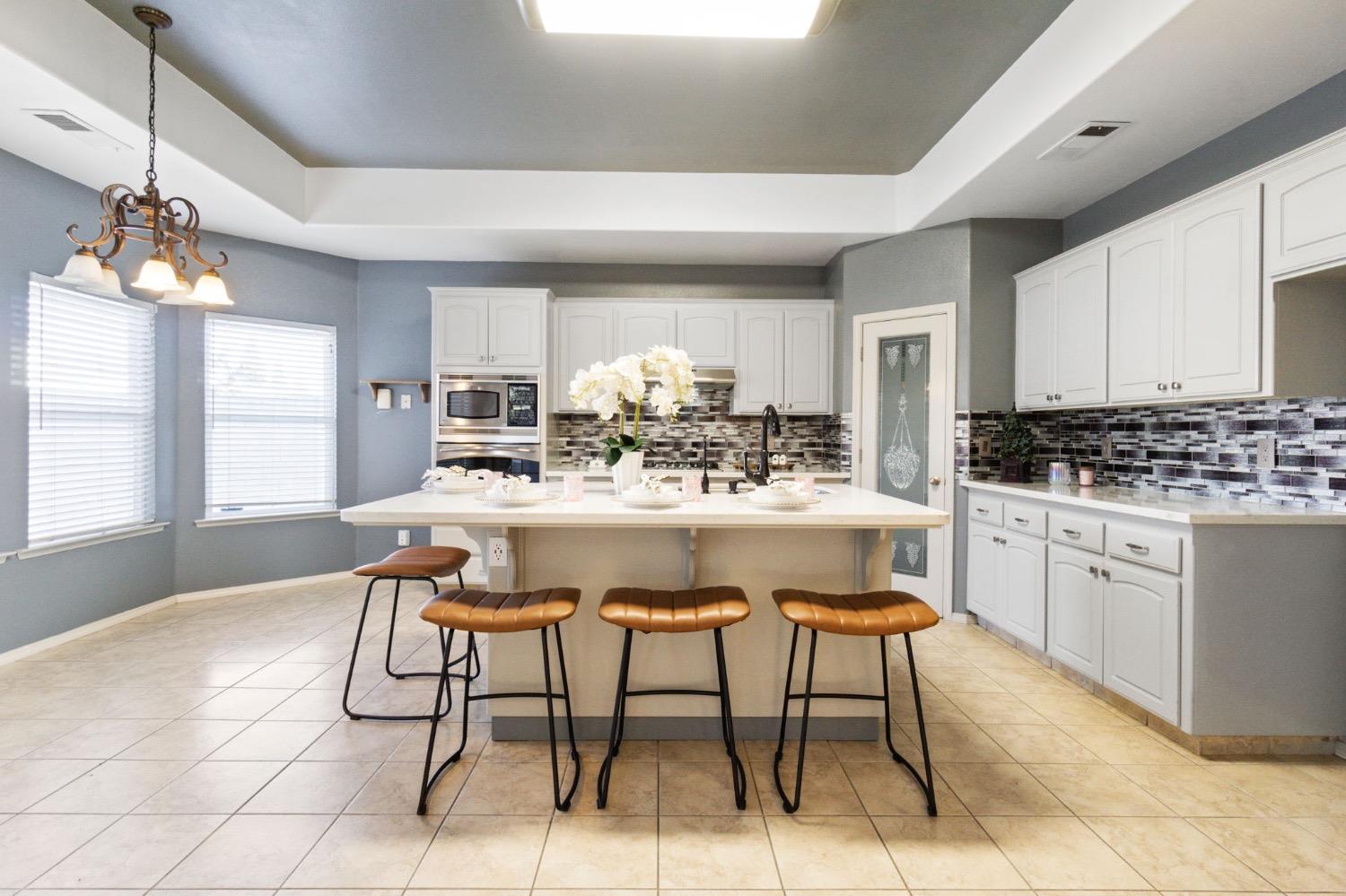3089 Express Court Madera, CA 93637 - Photo 5 of 39 a kitchen with stainless steel appliances kitchen island granite countertop a sink a stove a dining table and chairs