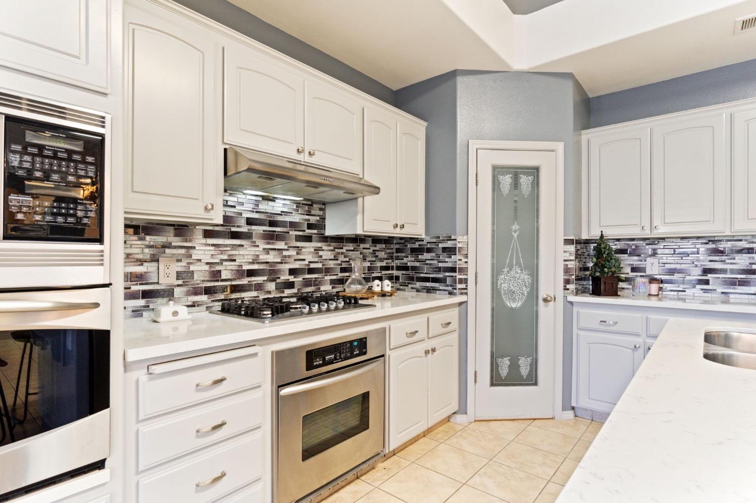 3089 Express Court Madera, CA 93637 - Photo 7 of 39 a kitchen with white cabinets and appliances