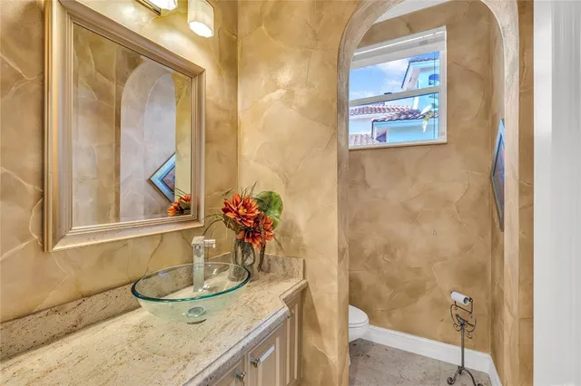 a bathroom with a granite countertop sink and a mirror a bathtub